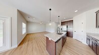 Located at 3866 S York Ave in Springfield, MO, this well-designed single-story home offers three bedrooms, two bathrooms, and a thoughtfully organized layout. Light-toned hardwood flooring runs throughout, creating a cohesive and airy feel across all living spaces.

The open-concept kitchen is a standout feature, anchored by a central island with a granite countertop, undermount sink, and pendant lighting. Rich dark-stained cabinetry, a white subway tile backsplash, stainless steel appliances, and a dedicated pantry complete the kitchen. The adjoining living and dining areas are bright and open, with recessed lighting, ceiling fans, and windows that allow generous natural light.

The primary bedroom is generously sized with a ceiling fan and large window with outdoor views. Its en-suite bathroom features a dual-sink vanity with granite countertops, dark wood cabinetry, and a glass-enclosed shower. The additional bedrooms are well-proportioned, each with closets and easy hallway access.

Two hallways connect the home's spaces efficiently, accompanied by a laundry room and utility room for added convenience. The attached garage offers ample space with overhead lighting and an automatic opener. Throughout, Shaker-style doors with matte black hardware lend a clean, modern aesthetic to this move-in-ready home.