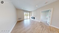 This single-floor residence at 505 Sutton St in North Andover, Massachusetts, presents a thoughtfully designed layout with contemporary finishes throughout. The kitchen serves as a central highlight, featuring crisp white cabinetry extending to the ceiling, a striking quartz-topped island with elegant veining, pendant lighting, a neutral tile backsplash, and a full suite of stainless steel appliances. Light hardwood-style flooring runs through the kitchen and main living areas, creating a cohesive, clean aesthetic.

The living area is bright and open, anchored by a sleek, modern fireplace with a linear design. A sliding glass door provides direct access to an outdoor space and allows natural light to fill the room. Neutral warm-toned walls complement the light flooring throughout.

The bedrooms are carpeted for comfort and feature large windows that frame outdoor views, filling the rooms with natural light. One bedroom includes a generous walk-in closet fitted with multi-level wire shelving and racking, while an additional closet provides supplementary storage. The overall design palette—neutral tones, clean lines, and quality materials—creates a cohesive, move-in-ready living environment.