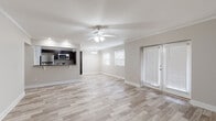 This single-floor home presents a thoughtfully designed layout with a cohesive, neutral color palette that creates a bright and welcoming atmosphere throughout. The open-concept living and dining area is a standout feature, showcasing light-toned wood-look flooring, crown molding, and a ceiling fan with integrated lighting. French doors with slatted blinds provide natural light and direct access to the outdoors, further enhancing the airy feel of the space.

The kitchen is efficiently designed with dark espresso cabinetry, granite countertops, and a full suite of stainless steel appliances, including a refrigerator, range, and over-the-range microwave. A pass-through opening connects the kitchen to the main living area, promoting an open and interactive flow.

The bedrooms feature plush wall-to-wall carpeting, ceiling fans, and windows with blinds that allow for natural light while maintaining privacy. Each room offers a calm, neutral environment well-suited for rest and relaxation.

The bathroom is finished with wood-look tile flooring, a dark vanity topped with granite, a tiled tub-shower combination, and brushed nickel fixtures, bringing together both function and style in a clean, modern presentation.