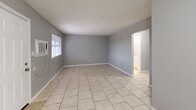 Located at 4759 NW Motif Manor Blvd in Lawton, Oklahoma, this single-story, 2-bedroom, 1-bathroom home offers a practical and functional layout. Light-toned tile flooring runs throughout the entire home, providing a clean and cohesive look across every room.

The living room is a well-proportioned open area featuring gray-painted walls, a wall-mounted AC unit, and windows fitted with blinds that allow natural light to filter in. A central hallway connects the main living areas to the two bedrooms and bathroom.

The galley-style kitchen is efficiently designed, featuring dark cabinetry contrasted against light granite-style countertops, a double stainless steel sink, white appliances including an electric range and refrigerator, and an overhead exhaust hood. The layout maximizes usable counter and storage space.

Both bedrooms are finished with the same neutral gray walls and tile flooring, each with a window providing natural light. The primary bedroom is a comfortable size and includes a wall-mounted AC unit.

The bathroom is highlighted by a full tub-and-shower combination enclosed by large-format marble-style tiles in warm gray tones, lending a clean and polished aesthetic. A connecting hallway ties all rooms together in a straightforward, easy-to-navigate floor plan.