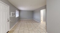 Located at 4759 NW Motif Manor Blvd in Lawton, Oklahoma, this single-story, 2-bedroom, 1-bathroom home offers a practical and functional layout. Light-toned tile flooring runs throughout the entire home, providing a clean and cohesive look across every room.

The living room is a well-proportioned open area featuring gray-painted walls, a wall-mounted AC unit, and windows fitted with blinds that allow natural light to filter in. A central hallway connects the main living areas to the two bedrooms and bathroom.

The galley-style kitchen is efficiently designed, featuring dark cabinetry contrasted against light granite-style countertops, a double stainless steel sink, white appliances including an electric range and refrigerator, and an overhead exhaust hood. The layout maximizes usable counter and storage space.

Both bedrooms are finished with the same neutral gray walls and tile flooring, each with a window providing natural light. The primary bedroom is a comfortable size and includes a wall-mounted AC unit.

The bathroom is highlighted by a full tub-and-shower combination enclosed by large-format marble-style tiles in warm gray tones, lending a clean and polished aesthetic. A connecting hallway ties all rooms together in a straightforward, easy-to-navigate floor plan.