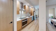 Located at 600 North Avenue in New Rochelle, NY, this one-bedroom, one-bathroom residence offers a well-appointed layout with modern finishes and a cohesive design aesthetic throughout. Light wood flooring flows across the entire space, creating a warm and unified feel from room to room.

The living area is bright and inviting, anchored by large black-framed windows dressed with sheer linen curtains that allow natural light to filter in. A compact dining nook sits adjacent to the living space, seamlessly connecting to the kitchen. The kitchen is a standout feature, outfitted with flat-front natural wood cabinetry, white quartz countertops, a white tile backsplash, stainless steel appliances, and a sleek wall-mounted range hood — a clean, contemporary design that balances form and function.

The bedroom is a calm retreat with neutral walls, a double-door wood wardrobe with matte black hardware, and an exposed concrete accent column that adds an industrial touch. An arched opening connects the bedroom to the living area, enhancing the open flow of the space.

The bathroom is elegantly finished with full marble mosaic tile in the walk-in shower, a glass enclosure, brushed gold fixtures, and a crisp white vanity — delivering a spa-like atmosphere. Every detail of this residence reflects a refined, modern sensibility.