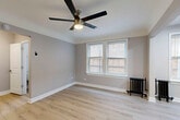 Located at 212 S Oak Park Ave in the vibrant community of Oak Park, Illinois, this efficiently designed single-floor unit makes excellent use of its intimate footprint. The combined living and dining area serves as the heart of the space, featuring light-toned hardwood flooring, soft gray walls with crisp white trim, and a sleek ceiling fan with integrated lighting. Natural light flows in through double-hung windows, while classic cast-iron radiators provide a charming nod to the building's architectural heritage.

The kitchen is a standout feature, boasting two-tone cabinetry with navy lower cabinets and white upper cabinets, complemented by brushed gold hardware. A striking marble-style quartz backsplash and countertops tie the design together, while stainless steel appliances — including a gas range, over-the-range microwave, and French door refrigerator — provide modern functionality. Additional windows in the kitchen area bring in further natural light and reinforce the bright, airy atmosphere throughout.

Hardwood flooring continues seamlessly through the hallway, connecting the living area to the bathroom and closet. The overall aesthetic is clean and contemporary, balancing updated finishes with classic architectural details, creating a cohesive and inviting living environment.