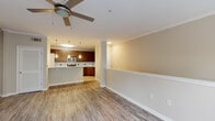 This two-story residence in Columbus, GA (31909) offers a well-designed layout that balances functionality and comfort across both levels. The main living area features wood-look laminate flooring, crown molding, and a ceiling fan, creating a bright and welcoming atmosphere. A half-wall partition subtly defines the transition between the living and dining spaces, while a decorative column adds an architectural accent.

The kitchen is thoughtfully appointed with rich, dark-stained wood cabinetry, granite countertops, a white subway tile backsplash, and a full suite of stainless steel appliances including a refrigerator, electric range, microwave, and dishwasher. Pendant lighting above the kitchen bar area adds a warm, modern touch, and tile flooring throughout the kitchen ensures easy maintenance.

The bedrooms are finished with plush carpeting and ceiling fans, providing a comfortable retreat, with windows that bring in natural light. The bathroom features a granite-topped vanity with dark wood cabinetry, tile flooring, and a tub-shower combination with tile surround.

On the lower level, a spacious attached garage with an automatic opener provides secure parking and additional storage. A carpeted staircase with a security panel and fire alarm connects the garage level directly to the main living floor, offering both convenience and peace of mind.