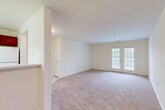 Located at 1050 Claire Taylor Ct in Culpeper, Virginia, this single-story, three-bedroom, two-bathroom home offers a well-organized and functional layout. The spacious living room is bathed in natural light through a set of French doors that open to the outdoors, and the room is finished with soft wall-to-wall carpeting that extends throughout the main living areas. A pass-through kitchen connects seamlessly to the dining area, featuring warm wood cabinetry, light countertops, white appliances including a range and dishwasher, and tile flooring — a practical and efficient space for everyday cooking. The open flow between the kitchen, dining room, and living room creates a welcoming, connected atmosphere ideal for both daily living and entertaining. Down the hallway, three bedrooms provide comfortable accommodations, each with plush carpet and clean white walls. The primary bedroom offers a generous footprint with ample room for furnishings. Five closets throughout the home ensure abundant storage. The two bathrooms are finished with tile flooring, wood-toned vanities, and light countertops. A dedicated laundry room adds everyday convenience. The home's neutral palette and consistent finishes create a clean, move-in ready environment throughout.