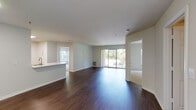 This single-floor residence offers a thoughtfully designed layout with a blend of modern finishes and functional living spaces. The expansive open-plan living and dining area is anchored by rich, dark hardwood flooring that extends throughout the main living spaces, creating a warm and cohesive aesthetic. Large sliding glass doors in the living area flood the space with natural light and provide views of lush surrounding greenery, while a kitchen pass-through adds to the open, airy feel.

The kitchen is well-equipped with crisp white shaker-style cabinetry, light countertops, a classic subway tile backsplash, and a full suite of stainless steel appliances including a gas range and over-the-range microwave.

Two generously sized bedrooms feature plush wall-to-wall carpeting and large windows that invite natural light and outdoor views. Each bedroom includes closet storage, with one featuring double closet doors. Both bathrooms are finished in a clean, neutral palette with white vanities, framed mirrors, and tiled tub-shower combinations. One bathroom includes a window for added ventilation and natural light. The overall ambiance of the space is bright, clean, and move-in ready.