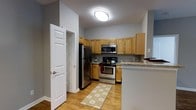 Located at 80 Jefferson Blvd in Fishkill, NY, this two-bedroom, two-bathroom residence offers a thoughtfully designed single-floor layout that maximizes comfort and functionality. The kitchen is a standout feature, equipped with stainless steel appliances including a range, built-in microwave, and refrigerator. Warm honey-toned wood cabinetry provides generous storage, while granite countertops add a touch of elegance. A peninsula counter creates a natural division between the kitchen and the adjoining living areas, ideal for casual dining or meal prep. The kitchen also benefits from a practical walk-in pantry or utility closet, offering additional storage space. Light hardwood-style flooring runs throughout, contributing to a bright and cohesive aesthetic. Flush ceiling lighting keeps the space well-lit and clean in appearance. The neutral gray wall tones provide a versatile backdrop suitable for a variety of décor styles. With two full bathrooms and two bedrooms, the floor plan accommodates both privacy and everyday convenience. The overall ambiance is welcoming and move-in ready, making this residence a practical and comfortable home in the Hudson Valley region of New York.
