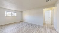 This single-floor unit offers a bright, clean, and well-maintained living environment with a consistent design aesthetic throughout. Light-toned luxury vinyl plank flooring runs seamlessly across every room, contributing to an open and airy feel that is further enhanced by crisp white walls and white baseboards.

The living area is generously proportioned, benefiting from natural light through a window that overlooks mature outdoor trees. A ceiling fan is present in the dining or flex area, which connects directly to the kitchen. The kitchen is efficiently laid out in an L-shape and features white shaker-style cabinetry, stainless steel countertops, and a full suite of stainless steel appliances including a range, microwave, dishwasher, and refrigerator. A window above the sink, fitted with blinds, brings in additional natural light.

The bedrooms are well-sized and offer a clean, neutral palette. Each bedroom includes a sliding-door closet with built-in hanging rods, providing practical storage. The full bathroom is finished with large-format white subway tile surrounding the tub-shower combo, complemented by a white vanity and matching flooring. Baseboard heating units are present throughout, and the unit includes a dedicated entry door. The overall ambiance is fresh, minimal, and move-in ready.