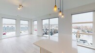 Located at 123 Water St in Norwalk, Connecticut, this modern single-floor residence showcases a clean, contemporary design throughout. The open-concept living and kitchen area is a central highlight, featuring light-toned hardwood-style flooring, a sleek white island with pendant lighting in warm brass tones, and floor-to-ceiling windows paired with sliding glass doors that open to a balcony with urban views of the surrounding Norwalk cityscape.

The kitchen is well-appointed with white flat-front cabinetry extending to the ceiling, quartz countertops, a white tile backsplash, and a full suite of stainless steel appliances including a gas range, built-in microwave, dishwasher, and refrigerator.

The bedrooms are carpeted and bright, each benefiting from large sliding glass doors or windows that invite natural light and outdoor views. Closets with sleek frosted glass sliding doors add a modern touch to the sleeping quarters.

The bathrooms are finished with light wood-toned vanities, quartz countertops, backlit mirrors, and neutral tile flooring. One bathroom features a soaking tub with elegant marble-style tile surround, while the second offers a clean, functional layout.

A light-filled hallway connects the private areas of the residence, maintaining the home's consistent modern aesthetic with crisp white walls and recessed lighting throughout.