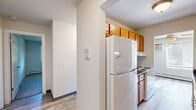 Located at 6421 Bridge Rd in Madison, Wisconsin, this single-floor residence offers three bedrooms, four bathrooms, and a well-organized layout designed for comfortable everyday living. The bedrooms are finished with soft carpeting and feature windows with blinds that allow natural light and views of the surrounding greenery. Each bedroom includes baseboard heating and wall-mounted air conditioning units, ensuring year-round comfort. At least one bedroom features a built-in sliding closet, providing practical storage. The bathrooms are a standout feature, with tiled tub-and-shower surrounds showcasing two distinct tile styles — one with a wood-look gray tile and another with a soft stone-patterned tile — paired with warm wood-toned vanities and light stone countertops. The kitchen is equipped with rich honey-toned cabinetry, dark laminate countertops, a double stainless steel sink, and ample upper and lower cabinet storage. Light wood-look flooring runs through the hallway and bathroom areas, creating a cohesive, clean aesthetic that connects the living spaces. The hallway is bright and open, linking the rooms efficiently. Overall, the home presents a clean, functional, and well-maintained environment suited for a variety of lifestyles.