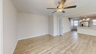 Located at 305 Hummingbird Ln in Oxford, NC, this two-story home offers three bedrooms, two bathrooms, and a well-designed layout spread across two floors. The main level features an open-concept kitchen and living area finished with light wood-look flooring throughout. The kitchen is a standout, boasting white shaker cabinetry, quartz countertops, stainless steel appliances, and a central island with a built-in sink and pendant lighting overhead — ideal for both cooking and casual dining. The living room is bright and open, with a ceiling fan and access to a sliding glass door that brings in natural light and outdoor views. A carpeted staircase leads to the upper level, where all three bedrooms are located. The primary bedroom is generously sized with plush carpet flooring and a ceiling fan. Additional bedrooms feature built-in closets with double doors. The bathrooms are clean and modern, with white cabinetry, quartz counters, brushed nickel fixtures, and tub-shower combinations. A dedicated laundry room with a window, washer, dryer, and overhead shelving adds everyday convenience. Neutral tones and consistent finishes throughout give the home a cohesive, move-in ready feel.