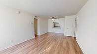 Located at 5675 Barnhill Dr in Jacksonville, FL, this single-story, one-bedroom, two-bathroom residence offers a practical and well-organized layout. The open combined living and dining area is a central highlight, featuring warm wood-look laminate flooring, a textured ceiling, and a ceiling fan with integrated lighting. Natural light filters in through a large window fitted with vertical blinds, creating a bright and airy atmosphere. A pass-through counter connects the living area directly to the kitchen, which is laid out in a galley style. The kitchen includes white cabinetry, granite-look countertops, a full suite of white appliances—including a refrigerator, electric range, and range hood—as well as a double sink and tile flooring. The bedroom is a comfortable size, featuring the same wood-look flooring, a closet, and a window with vertical blinds that allows for ample natural light. The unit includes two bathrooms: one full bath with white tile surround, a tub-shower combination, and granite-look countertops, and a second bath with a single vanity, mirror, and tile flooring. Four closets throughout the unit provide generous storage. A hallway connects the main areas, and the layout flows efficiently from room to room.