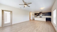 Located at 202 East Ufer Street in the heart of Fredericksburg, Texas, this single-story, 3-bedroom, 2-bathroom home offers a clean, modern design with a thoughtfully planned layout. The open-concept living room and kitchen area anchors the home, featuring light wood-style flooring and a ceiling fan that enhances airflow and comfort. The kitchen is a standout, showcasing dark espresso cabinetry, stainless steel appliances, a tile backsplash, track and pendant lighting, and a generous island with a striking marble-look countertop — ideal for both meal preparation and casual dining. The spacious primary bedroom is bathed in natural light from multiple windows and includes a ceiling fan, while a dedicated walk-in closet offers wire shelving for ample storage. Secondary bedrooms are carpeted with their own windows and ceiling fans. The bathrooms feature dark cabinetry with light countertops, wood-style flooring, and tub-shower combinations. A dedicated laundry room accommodates a full-size washer and dryer with overhead wire shelving. The home's neutral palette and consistent finishes throughout create a cohesive, move-in-ready atmosphere well-suited for comfortable living in the Texas Hill Country.