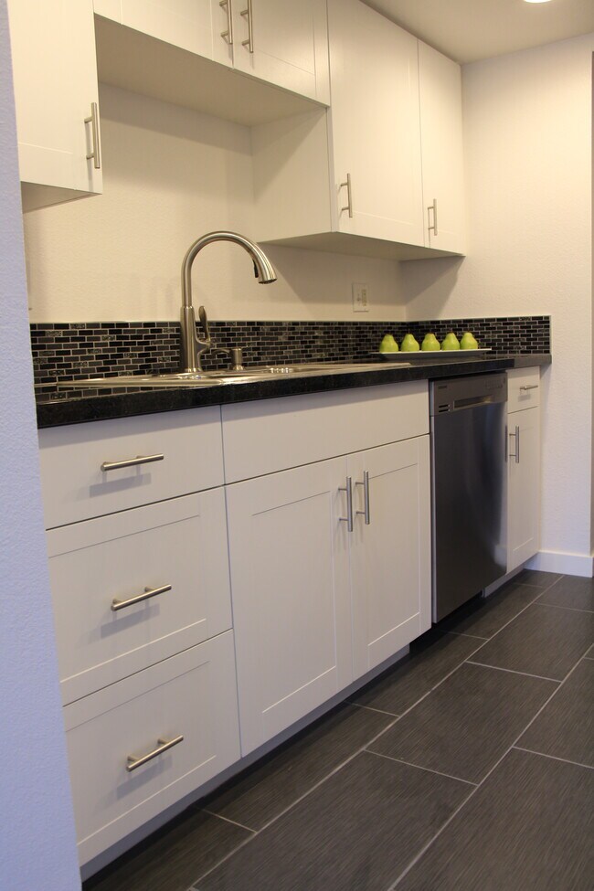 La cocina cuenta con suelo de baldosas y lavavajillas. - 10418 Northeast 32nd Place