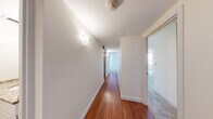 Located on Huntington Avenue in Boston's vibrant Fenway/Back Bay neighborhood, this two-bedroom, two-bathroom residence offers a functional and well-appointed single-floor layout. A welcoming hallway with warm hardwood flooring connects the living spaces, setting the tone for the home's clean, contemporary aesthetic.

The kitchen is efficiently designed with rich wood cabinetry, dark granite countertops, and a full suite of stainless steel appliances including a range, built-in microwave, dishwasher, and refrigerator. Hardwood floors extend through this space, adding warmth and continuity.

The spacious primary bedroom features plush carpeting, multiple closets offering generous storage, and large windows that frame views of the surrounding Boston cityscape. The second bedroom is equally well-sized, also carpeted, and benefits from abundant natural light through wide windows with urban views.

The living area is bright and open, with multiple windows drawing in natural light and providing expansive city views. Two bathrooms serve the residence, each featuring granite-topped vanities with brushed nickel fixtures and clean, neutral finishes. The overall ambiance is calm and functional, well-suited for urban living in one of Boston's most accessible and dynamic neighborhoods.