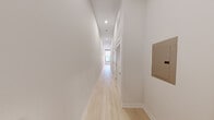 Located in the heart of downtown Pittsburgh on Sixth Avenue, this thoughtfully designed two-bedroom, two-bathroom unit offers a clean, modern aesthetic across a single floor. Light-toned hardwood flooring runs throughout the main living areas and bedrooms, creating a bright and cohesive look that complements the neutral, soft-gray walls and crisp white trim.

The kitchen is a functional highlight, featuring light gray shaker-style cabinetry, a herringbone tile backsplash, white quartz countertops, and a full suite of stainless steel appliances including a refrigerator, range, microwave, and dishwasher. Recessed lighting and notably high ceilings lend the open living and kitchen area an airy, spacious quality.

A well-proportioned hallway with recessed lighting and louvered closet doors connects the living areas to the bedrooms and bathrooms. The primary bedroom offers a comfortable footprint with a dedicated closet, while the second bedroom is equally well-sized. Each bedroom benefits from a clean, understated palette and easy access to the hallway.

Both bathrooms are finished with striking marble-look tile flooring and white subway-tiled shower-tub combinations. Each features a gray vanity with white countertop and a modern backlit mirror, delivering a polished, spa-like ambiance throughout.
