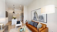 Located at 4841 Rouzan Square Ave in Baton Rouge, LA, this thoughtfully designed one-bedroom, two-bathroom residence offers a modern open-concept layout with high ceilings and light-toned finishes throughout. Light wood-style flooring flows seamlessly from the entry through the living and kitchen areas, creating a cohesive and airy atmosphere.

The kitchen is a standout feature, showcasing a long white quartz-topped island with pendant lighting, gray shaker-style cabinetry, and stainless steel appliances including a range, microwave, and refrigerator. The space opens directly into the living room, which is anchored by soaring ceilings and a wall of French doors topped with a transom window, inviting an abundance of natural light and views of the surrounding neighborhood.

The primary bedroom is a serene retreat with elevated ceilings, large windows dressed in sheer curtains, and carpet flooring. It connects to a well-appointed en-suite bathroom featuring gray dual-vanity cabinetry, white quartz countertops, and a glass-enclosed walk-in shower with tall ceilings that continue the sense of vertical space. A spacious walk-in closet with multi-level rod storage and wood-look flooring completes the bedroom suite.

A second full bathroom and a dedicated closet round out the functional layout of this well-finished Baton Rouge residence.