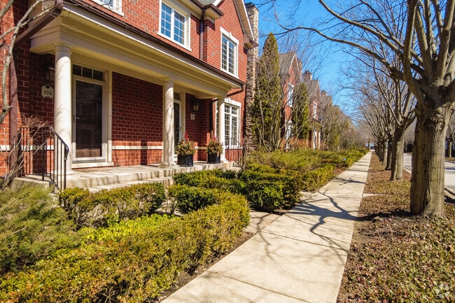 Sidewalks are lined with many trees and well kept greenery