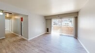 Located at 2401 Arlington Blvd in Charlottesville, VA, this 2-bedroom, 1-bathroom residence offers a well-organized, single-floor layout designed for comfortable living. Light-toned hardwood-style flooring runs throughout, lending a clean and cohesive look to every room.

The living room is a generous, open space anchored by large sliding glass doors with vertical blinds, providing direct access to an outdoor patio and allowing natural light to fill the room. A ceiling fan adds practical comfort to the adjacent area.

The kitchen features warm oak cabinetry offering ample storage, a stainless steel sink, and light countertops. A window brings in natural light, and the galley-style layout makes efficient use of the available space. A dishwasher is also included.

The primary bedroom is a comfortable retreat with its own walk-in closet complete with a hanging rod and shelf. The second bedroom includes a sliding closet with classic paneled doors and a window overlooking the exterior. Both rooms are finished with neutral walls and the same light flooring found throughout.

The full bathroom is equipped with a tub-shower combination and a curtain rod, keeping the space practical and functional. A dedicated closet provides additional storage. The overall aesthetic is clean, neutral, and move-in ready.