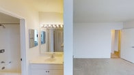 This single-floor space includes a bathroom vanity area and an adjacent carpeted room, both finished in clean, neutral tones. The bathroom features a white vanity with cabinetry below, a large mirror, and a Hollywood-style light bar that provides bright, even illumination. A second wall-mounted mirror is visible to the left, and louvered closet doors can be seen in the background, adding functional storage. The walls and surfaces are painted in soft white and cream tones, contributing to a bright and airy feel. The adjoining room, visible through the dividing wall, is carpeted in a neutral gray-beige, offering a versatile open space. Both areas share the same light, understated color palette, creating a cohesive and clean aesthetic throughout. The textured ceiling is consistent across the space, a common feature that adds subtle visual depth. Overall, the space presents a straightforward, functional layout with an emphasis on practical design elements and neutral finishes that provide a blank canvas for personalization.