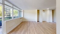 Located on Lakeshore Boulevard West in Toronto's vibrant Mimico neighbourhood, this one-bedroom, one-bathroom unit offers a practical and well-lit living space across a single floor. Light hardwood flooring runs throughout, lending a clean and cohesive feel to the interior.

The living room is bright and open, benefiting from large floor-to-ceiling windows that frame views of mature trees and the surrounding streetscape, allowing abundant natural light to fill the space. A baseboard heating unit sits beneath the windows, ensuring year-round comfort.

The kitchen is compact yet functional, featuring white cabinetry, a countertop with an integrated sink, and a window overlooking the outdoors. White subway tile accents add a classic touch to the space.

The bedroom is a well-proportioned room with large windows that continue the theme of natural light found throughout the unit. It includes a built-in closet with sliding doors, offering practical storage solutions.

The bathroom is finished with neutral beige wall tiles and matching floor tiles, and includes a full soaker tub with overhead shower, a pedestal sink, and a toilet — all in a clean, understated palette.

Overall, the unit presents a straightforward and functional layout with a bright, neutral aesthetic well-suited for comfortable everyday living.