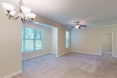 This single-floor residence offers a thoughtfully designed layout that balances comfort and functionality throughout. The open living and dining areas are finished with plush wall-to-wall carpeting and warm neutral tones, with crown molding and elegant chandelier lighting adding a refined touch. Multiple windows fitted with blinds allow abundant natural light to fill the space while offering views of lush greenery outside. A ceiling fan in the living area enhances comfort year-round.

The galley-style kitchen is well-equipped, featuring warm wood cabinetry, granite-style countertops, a double stainless steel sink, and black appliances including a range, microwave, refrigerator, and dishwasher. Light tile flooring and pendant lighting complete the kitchen's practical yet inviting character.

The bedrooms are generously proportioned, each with soft carpeting, neutral walls, and ample natural light. The primary bedroom benefits from a ceiling fan, multiple windows, and direct access to a spacious walk-in closet with wire shelving. The adjoining bathroom is finished with tile flooring, warm wood vanity cabinetry, granite countertops, and a clean, functional layout. A dedicated laundry area with washer and dryer hookups adds everyday convenience to this well-rounded home.