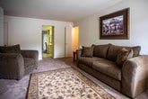 Located at 552 Live Oak Ln in Newport News, Virginia, this single-floor residence offers a thoughtfully laid-out living space designed for comfort and functionality. The living room is bright and inviting, featuring plush carpeting, natural light from a large front-facing window, and a welcoming entry door. The adjacent dining area continues the warm aesthetic with soft carpet flooring, vertical blinds over a sliding glass door that frames lush outdoor greenery, and a classic framed artwork accent on the wall. The kitchen is fitted with ample white cabinetry, light countertops, a stainless sink, and a built-in dishwasher, offering generous storage and prep space with tile flooring. The two bedrooms are generously sized, each with plush carpeting, large windows that bring in natural light and garden views, and closet storage. The primary bedroom features dual windows and an open closet, while the second bedroom includes a sliding-door closet. Two bathrooms serve the residence; one features tile flooring, a vanity with under-sink storage, and a shower-tub combination, while the second offers a similar clean, functional design. Throughout, the space maintains a neutral color palette and a calm, residential ambiance.