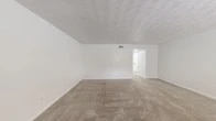 Located at 1570 Lane Ave S in Jacksonville, Florida, this two-story home offers three bedrooms and one bathroom across a well-organized layout. The main floor houses the living area, kitchen, and entry, while the upper floor accommodates the bedrooms and bathroom. Throughout the home, neutral-toned carpet and textured ceilings create a clean, consistent aesthetic.

The living room is open and bright, with carpet flooring and access to additional areas of the home via a hallway. A sliding glass door in one room allows natural light to pour in while offering a direct view to the outdoors. The kitchen features gray cabinetry, light stone-look countertops, a classic white subway tile backsplash, a double stainless steel sink, and wood-look flooring — all contributing to a fresh, updated feel.

Each of the three bedrooms is carpeted and equipped with a ceiling fan. The spacious primary bedroom connects to the shared bathroom and includes a closet. Additional bedrooms feature windows with blinds, providing natural light and privacy. The full bathroom is cleanly finished with a tub-shower combo, a single vanity with white countertop, a large mirror with black-framed accents, and wood-look flooring. A central staircase connects both floors, completing this functional and well-maintained home.