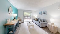Located at 4831 Summit Cir in Knoxville, TN, this single-floor, 2-bedroom, 2-bathroom residence offers a well-designed layout that balances comfort and style. Light wood-look flooring flows throughout the main living areas, complemented by a striking teal accent wall that anchors the spacious living room. A sliding glass door floods the living space with natural light and provides direct access to an outdoor patio area. Adjacent to the living room, a dedicated dining area features chair-rail molding and a pendant light fixture, creating a defined yet open space for meals. The kitchen is outfitted with crisp white cabinetry, granite countertops, a stainless steel sink, and black appliances including a range and refrigerator. An in-unit washer and dryer are also accommodated within the layout. Both bedrooms are carpeted and include ceiling fans, natural window light, and closet space, with the primary bedroom offering a generously sized reach-in closet. Each bathroom is finished with white vanity cabinetry, granite countertops, and a tub-shower combination. Textured ceilings are present throughout, adding a classic architectural touch to this well-appointed Knoxville residence.