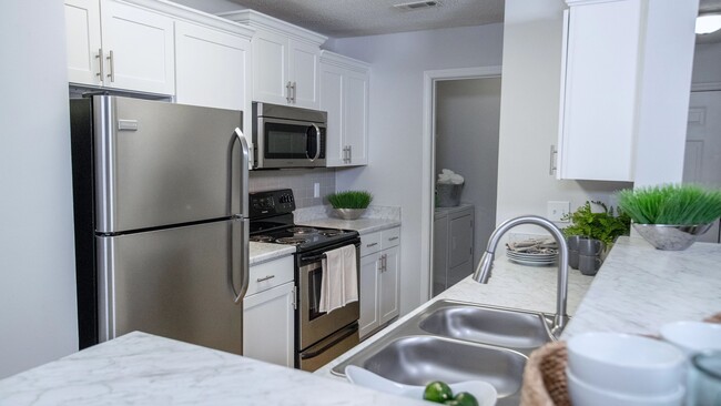 Carrara marble-inspired countertops grace the breakfast bar, creating a timeless and luxurious atmosphere in this expansive kitchen. Ample countertop space and storage ensure both style and functionality. - Emerson Isles