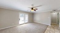 Located at 3280 Silver Springs Dr in Louisville, KY, this single-floor, 2-bedroom, 1-bathroom home offers a practical and comfortable layout. The living room features plush carpeting, crown molding, a ceiling fan with light fixture, and French doors that invite natural light and provide outdoor access. Adjacent to the living room, the kitchen is outfitted with white cabinetry, granite-style countertops, a black gas range, stainless steel microwave, and a sink with a window, all set over light ceramic tile flooring. A dedicated laundry area with overhead cabinetry and utility hookups provides added convenience. The primary bedroom is a well-proportioned retreat with soft carpeting, natural light from a window with blinds, a ceiling fan, and dual closets with six-panel doors. The second bedroom also features carpet and neutral walls, offering a clean and versatile space. The full bathroom includes a tub-shower combination with chrome fixtures and tile flooring. Throughout the home, neutral warm-toned walls, consistent trim work, and ceiling fans create a cohesive and functional living environment suited for everyday comfort.
