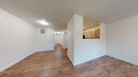 Located at 190 Rue Sans Souci in Bethalto, Illinois, this single-floor unit offers a clean, straightforward layout designed for comfortable everyday living. Warm wood-look flooring runs consistently throughout the space, providing a cohesive and inviting aesthetic from room to room. The open living and dining areas are bright and neutrally finished with white walls and textured ceilings, creating a versatile canvas for a variety of furnishing styles. A half-wall pass-through connects the living area to the kitchen, enhancing the sense of openness between the two spaces. The kitchen is well-equipped with gray cabinetry featuring raised-panel doors, light granite-style countertops, a double sink, and black appliances including a refrigerator and range. Ample upper cabinet storage adds practical functionality. A hallway leads to the additional rooms, including a bedroom with a window that allows natural light and views of the surrounding exterior. The bathroom features a clean white finish with wood-look flooring, grab bars, and a toilet and vanity. A closet provides convenient storage off the kitchen area. The overall design is clean, practical, and move-in ready, suited for those seeking a well-maintained space in a quiet Bethalto neighborhood.