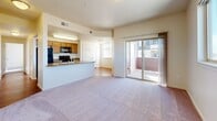 Located at 2770 Copper Peak Ln in Longmont, Colorado, this two-bedroom, one-bathroom home offers a well-organized single-floor layout designed for comfortable everyday living. The open-concept main area seamlessly connects the kitchen, dining, and living spaces, creating a cohesive and functional hub. The kitchen is equipped with wood-toned cabinetry, black appliances including a refrigerator, range, and over-the-range microwave, and a peninsula counter that provides additional workspace and a natural divider from the living area. The living room features soft carpeting and is anchored by sliding glass doors that open onto a private balcony, filling the space with natural light and views of the surrounding area. Both bedrooms are carpeted and well-lit by large windows, with the primary bedroom offering generous proportions and access to multiple closets. A hallway connects the bedrooms to the shared full bathroom, which includes a tub-shower combination, hardwood-style flooring, and a vanity with storage. Additional highlights include a library or flex room, multiple closets for ample storage throughout, and consistent warm, neutral tones across all rooms that contribute to a bright and inviting atmosphere.