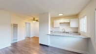 Located at 3351 Marine Ave in Gardena, CA, this thoughtfully laid-out one-bedroom, one-bathroom unit offers a clean, modern aesthetic across a single floor. Wood-look plank flooring runs throughout the entire space, providing a cohesive and contemporary feel.

The open-concept living and kitchen area serves as the heart of the unit. The kitchen features white cabinetry, a granite-style countertop peninsula that doubles as a breakfast bar, and a stainless steel sink beneath a window that lets in natural light. A ceiling fan overhead keeps the living area comfortable and well-ventilated.

The spacious bedroom is bright and airy, with a wide window fitted with blinds that allow for adjustable natural light. A full-wall built-in closet with sliding doors and additional upper cabinet storage provides generous organization space.

The bathroom is clean and bright, finished in white tile with a tub/shower combination, a vanity with white cabinetry and chrome hardware, a round mirror, and a window for natural ventilation.

Throughout the unit, neutral white walls, clean trim, and consistent flooring create a light, inviting ambiance that is both functional and easy to personalize. The overall design is simple and practical, making efficient use of the available space.