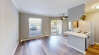 Located at 4828 Zenith St in Metairie, Louisiana, this one-bedroom, one-bathroom unit offers a well-designed, efficiently organized floor plan across a single level. Hardwood-style laminate flooring runs throughout, complemented by clean white baseboards and crown molding that lend a polished, cohesive look to every room.

The living room is the heart of the unit, brightened by large windows and a sliding glass door that opens to a private balcony, flooding the space with natural light. A ceiling fan overhead adds comfort, while a partial-wall countertop separates the living area from the adjacent kitchen, which features a white appliance suite and built-in cabinetry.

A long, well-lit hallway connects the main living area to the private quarters, with a flush-mount ceiling fixture adding a warm glow. The bedroom is comfortably sized, featuring its own ceiling fan, a closet, crown molding, and a window offering an exterior view. The bathroom is clean and functional, appointed with a full-size soaking tub and shower combination with a crisp white surround and chrome fixtures.

The unit's neutral gray walls, consistent flooring, and understated finishes create a calm, move-in-ready atmosphere throughout.