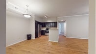 This single-floor residence offers a thoughtfully designed layout that balances functionality and comfort. The open-concept living and dining area is finished with warm hardwood-style flooring, crown molding, and a ceiling fan with light fixture. French doors invite natural light into the living space and provide access to the outdoors.

The kitchen is a standout feature, showcasing dark espresso cabinetry, a tasteful tile backsplash, light stone countertops, and a full suite of stainless steel appliances including a refrigerator, electric range, and microwave. A peninsula counter extends the workspace and creates a natural separation between the kitchen and living areas. Track lighting overhead ensures the space is well-illuminated.

The bedrooms are carpeted for comfort and each includes a ceiling fan with light. One bedroom features a walk-in closet, while another benefits from a window that fills the room with natural light. An additional room with hardwood-style flooring and a louvered closet door offers flexible use as a bedroom or office.

Two full bathrooms serve the home, each featuring dark vanity cabinetry, light countertops, large mirrors, and a tub-shower combination with tiled surrounds. Hardwood-style flooring carries through both bathrooms, maintaining a cohesive aesthetic throughout the residence.