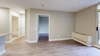 Located at 151 Beecroft Road in North York, Toronto, this efficient one-bedroom, one-bathroom unit offers a well-considered layout that maximizes every square foot of its compact footprint. Light-toned laminate flooring runs throughout, complementing the neutral warm-beige walls and crisp white trim that give the space a clean, contemporary feel.

The combined kitchen and living area forms the heart of the unit. The kitchen is equipped with stainless steel appliances — including a full-size refrigerator, electric range, and built-in microwave — set against white shaker-style cabinetry with ample storage. A peninsula with a light quartz countertop doubles as a breakfast bar and provides additional prep space. Track lighting overhead ensures the kitchen is well-lit.

The living area flows naturally from the kitchen and leads to a private balcony through a full-height glass sliding door, offering views of the surrounding Toronto skyline — an ideal spot to take in the urban landscape.

The bedroom is a well-proportioned retreat featuring a window with city views, light laminate flooring, and a built-in sliding-door closet providing practical storage. The four-piece bathroom is finished with clean white subway-tiled walls surrounding a soaker tub and shower combination, maintaining the unit's consistent, understated aesthetic throughout.