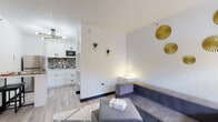 Located at 1255 S SH 6 Access Rd in Houston, TX, this single-floor unit offers a thoughtfully designed open-concept layout that maximizes its compact footprint. Light-toned luxury vinyl plank flooring flows throughout the space, creating a cohesive and clean aesthetic.

The living area is bright and inviting, featuring white walls accented with gold decorative elements, a textured ceiling, and a window that allows natural light to filter in. A gray sectional sofa and ottoman furnish the space comfortably, while a wall-mounted TV and a white dresser with gold hardware add functional style.

The kitchen is efficiently designed with crisp white shaker-style cabinetry featuring matte black hardware, a mosaic tile backsplash, stainless steel appliances including a full-size refrigerator and microwave, and a stainless steel sink. A compact bistro-style table with a bar stool provides a practical dining solution adjacent to the kitchen.

The bathroom maintains the unit's clean, modern palette with a wide white countertop, an undermount sink, a large mirror, a recessed medicine cabinet, and wood-look flooring that ties seamlessly to the rest of the unit. A shower with a patterned curtain completes the space.

Overall, this unit delivers a modern, well-appointed living environment with cohesive contemporary finishes throughout.