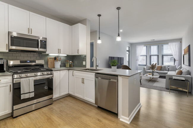 Renovated Package II kitchen and living room with hard surface flooring - Avalon at Assembly Row