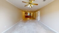 Located at 3020 Billy Jack Dr in Conway, Arkansas, this single-story, 2-bedroom, 2-bathroom home offers a practical and comfortable layout across a well-utilized floor plan. The entrance leads into a hallway finished with light tile flooring and crown molding, connecting the main living areas seamlessly. The spacious living room features plush carpet, a ceiling fan with light fixture, and crown molding, opening directly into the combined dining room and kitchen. The kitchen is equipped with warm oak cabinetry, a peninsula countertop with ample workspace, a built-in sink, white electric range, black refrigerator, and a built-in microwave — all finished with light tile flooring. The primary bedroom is generously sized, filled with natural light from a window, carpeted floors, a ceiling fan, and access to two closets. The second bedroom also features carpet, a ceiling fan, and its own closet. Both bathrooms include tub/shower combinations with sliding glass enclosures and tile flooring. Additional highlights include a dedicated laundry room, a utility room, and an attached garage with an automatic opener, textured ceiling, and concrete floors — offering excellent storage and parking capability. Six closets throughout the home provide exceptional storage.
