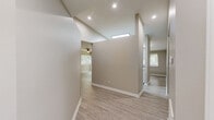 Located at 130 W Crescent Square Dr in Graham, NC, this single-floor residence offers a well-organized layout featuring two bedrooms, two bathrooms, a living room, a utility room, a closet, and connecting hallways. The living room is finished with light-toned wood-look laminate flooring and is equipped with a ceiling fan with integrated lighting. A window with blinds allows natural light to filter in, offering views of surrounding greenery, creating a bright and welcoming atmosphere. Neutral greige walls and crisp white trim are carried consistently throughout the home, lending a clean and cohesive aesthetic. Both bedrooms are carpeted in a warm, neutral tone and receive natural light through windows fitted with blinds. The generously sized primary bedroom provides comfortable living space. Both bathrooms are finished with wood-look flooring and feature tub-shower combinations with curved curtain rods, white vanities with light stone-style countertops, and clean white fixtures. A dedicated utility room adds practical convenience to the home. The overall design is straightforward and functional, with consistent finishes throughout that make this residence a comfortable and move-in ready option in Graham, NC.