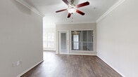 Located in Houston's 77056 zip code, this two-bedroom, one-bathroom single-floor residence offers a well-designed layout with consistent dark hardwood-style flooring throughout. The open living area is highlighted by crown molding, a ceiling fan, and multiple windows with blinds that invite natural light while maintaining privacy. A door provides direct outdoor access from the living space.

The kitchen is thoughtfully appointed with rich dark cabinetry, a warm stone-toned backsplash, light granite-style countertops, and a full suite of stainless steel appliances including a refrigerator with ice maker, electric range, over-the-range microwave, and dishwasher. A window above the sink adds brightness to the workspace.

The spacious primary bedroom features its own ceiling fan, large windows, and generous proportions. The second bedroom is equally bright with a ceiling fan and window overlooking greenery. Both rooms share a well-sized full bathroom equipped with a dual-sink vanity featuring dark cabinetry and a full tub-shower combination with white tile surround.

Additional highlights include a walk-in closet with built-in wire shelving and an in-unit laundry area with full-size washer and dryer. Built-in shelving in the hallway provides extra storage. The layout is practical and cohesive, offering comfortable everyday living.