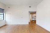 Located at 100 Cabot Street in Boston, MA, this thoughtfully designed single-floor residence offers four bedrooms and two bathrooms across a generously sized layout. The interior showcases a clean, modern aesthetic defined by warm hardwood flooring, high ceilings, and crisp white walls throughout.

The spacious living room provides an open, airy atmosphere and flows seamlessly into the kitchen, which is outfitted with white shaker-style cabinetry, light countertops, and a full suite of stainless steel appliances including a refrigerator, range, microwave, and dishwasher — ideal for everyday living and entertaining.

The four bedrooms are bright and well-proportioned, each featuring hardwood floors and large windows with roller shades that frame views of the surrounding Boston streetscape. The primary bedroom offers a comfortable, generous footprint among the four. A bold yellow entry door adds a distinctive character to the hallway entrance.

The two bathrooms are finished with neutral tile flooring, white vanities with ample drawer storage, and chrome fixtures. One bathroom features a walk-in shower, while the other includes a full soaking tub with shower — catering to a range of preferences. The overall ambiance of the home is modern, clean, and move-in ready.