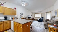 Located at 12555 Pennock Ave in Apple Valley, Minnesota, this two-bedroom, two-bathroom single-floor home offers a functional and well-organized layout. The open-concept kitchen and living area serves as the heart of the home, where vaulted ceilings add a sense of airiness and volume. The kitchen is equipped with warm oak cabinetry, a U-shaped counter layout, white appliances, and a central island with seating — ideal for casual dining and meal preparation. The living area flows naturally from the kitchen, featuring wood-style flooring, a ceiling fan, and windows that bring in natural light.

Both bedrooms are carpeted and comfortably sized, each with access to closet storage. The primary bedroom offers generous space, while the second bedroom includes a window with room-darkening curtains. The two bathrooms are finished with oak vanities and wood-style flooring; one includes a full tub/shower combo, while the other features a single-sink vanity. A dedicated in-unit laundry room with side-by-side washer and dryer hookups and wall shelving adds everyday convenience. With four closets distributed throughout, storage is plentiful. The home's neutral palette and cohesive oak trim details create a warm, consistent aesthetic throughout.