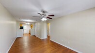 Located at 1817 Amberwood Dr in Center Point, Alabama, this single-story, 2-bedroom, 1-bathroom home offers a practical and comfortable layout. The living room features warm hardwood-style flooring, a ceiling fan with light fixture, and a large window that allows natural light to fill the space. A front entry door with an adjacent window adds additional brightness to the area.

The kitchen is laid out in a galley style, equipped with light oak cabinetry, laminate countertops, a stainless steel sink, and black appliances including a range, hood vent, and refrigerator. A rear-facing door provides convenient back access and adds natural light to the kitchen.

Both bedrooms are carpeted and include ceiling fans with lighting. The primary bedroom offers a generous footprint, while the secondary bedroom features a double-door closet and a window with natural views. Each bedroom connects to a central hallway that links the main living areas.

The bathroom includes a full tub and shower unit with a white surround and built-in shelving, offering a clean and functional design. Throughout the home, neutral beige walls and white trim provide a consistent, understated aesthetic well-suited for personalization.
