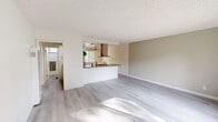 Located in Cerritos, CA, this single-story 2-bedroom, 2-bathroom home offers a well-organized layout designed for comfortable everyday living. The open living and dining area is bright and airy, featuring light wood-style flooring, neutral-toned walls, and a textured ceiling that carries throughout the home. A large sliding window allows natural light to fill the space, creating a welcoming atmosphere.

The kitchen is thoughtfully designed with white cabinetry, a mosaic tile backsplash, dark stone countertops, and stainless steel appliances including a refrigerator and built-in microwave. A pass-through counter connects the kitchen to the dining area, enhancing the open flow of the space. A ceiling fan with a light fixture and a window overlooking greenery add both function and charm to the kitchen-dining area.

Both bedrooms are carpeted and equipped with ceiling fans and windows that offer views of surrounding greenery. The primary bedroom includes a mirrored sliding-door closet, while the second bedroom provides comfortable space and natural light.

The two bathrooms feature white cabinetry, gray stone countertops, and large mirrors. One bathroom includes a walk-in shower, and both are finished in a clean, neutral palette. The home's consistent finishes and practical layout make it a functional and inviting residence.