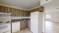 Located at 8306 NW Seventh St in Miami, FL, this two-floor property offers a clean, functional layout with consistent design elements throughout. Large-format marble-look porcelain tile flooring runs seamlessly across all rooms, lending a bright and polished aesthetic to the entire space.

The entry level welcomes you with a sun-filled foyer featuring a white staircase with balustrade leading to the upper floor. The spacious living area is bathed in natural light from multiple windows dressed with vertical blinds, complemented by a textured ceiling and central light fixture. The kitchen is well-appointed with warm wood-grain laminate cabinetry extending to the ceiling, granite-look countertops, a stainless steel sink, and white appliances including a refrigerator, electric range with overhead exhaust, and dishwasher.

The bathroom features full beige ceramic tile wall surrounds in the tub/shower area, a compact vanity with wood-grain finish, and a window for natural ventilation. Bedrooms are generously sized, each offering windows with vertical blinds that bring in ample natural light. At least one bedroom includes a reach-in closet with built-in shelving. A bedroom with an en-suite bath adds added convenience. Throughout, the bright white walls and neutral tones create a light, airy ambiance well-suited to Miami's sunny climate.