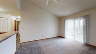 Located at 2389 Bayside Dr in Columbus, Ohio, this single-floor unit offers a practical and comfortable layout throughout. The living room is generously sized, featuring plush carpeting, vaulted ceilings, a ceiling fan, a textured ceiling, and a sliding glass door fitted with vertical blinds that invite natural light and provide access to an outdoor area. The open feel of the living space makes it a welcoming central hub of the unit. The kitchen is well-appointed with warm medium-toned wood cabinetry, granite-style countertops, wood-look vinyl flooring, and white appliances including a refrigerator and electric range with an overhead exhaust fan. Ample upper cabinet storage and a breakfast bar-style counter add both function and convenience. The bedrooms are carpeted and finished with warm neutral tones, wood baseboards, and textured ceilings. One bedroom features a window with natural views, while another connects to a spacious walk-in closet outfitted with wire shelving on multiple walls, offering generous storage capacity. The bathroom includes a full soaking tub and shower combo, a toilet, and a granite-style vanity countertop, all finished in a clean, neutral palette. Throughout the unit, consistent neutral wall tones and carpeted floors create a cohesive and move-in-ready atmosphere.