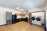 Located at 715 N 16th St in Baton Rouge, Louisiana, this single-floor, one-bedroom, two-bathroom residence offers a practical and well-appointed layout. Warm-toned wood-look flooring runs consistently throughout the unit, creating a cohesive and inviting feel.

The kitchen is a standout feature, equipped with dark lower cabinets, warm wood upper cabinetry, light granite-style countertops, and black appliances including a refrigerator, gas range, and dishwasher. A stainless steel wall-mounted range hood provides ventilation, and a skylight panel brightens the space. A ceiling fan overhead adds comfort, and an in-unit washer and dryer are conveniently located adjacent to the kitchen area.

The generously sized primary bedroom offers ample room, a ceiling fan, a built-in closet, and access to a secondary space with additional dark cabinetry for storage. Clean white walls and dark door trim provide a crisp, modern contrast throughout.

Both bathrooms are designed with accessibility in mind, featuring stainless steel grab bars along the walls. One bathroom includes a walk-in shower with built-in safety bars, while the other provides a spacious layout with over-toilet storage cabinetry. Wood-look flooring carries into both bathrooms, maintaining the unit's consistent aesthetic.