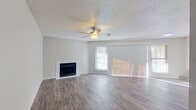 This single-floor residence offers a functional and comfortable layout across two bedrooms and two full bathrooms. The living room serves as the heart of the home, featuring a classic fireplace, a ceiling fan, textured ceiling, and large sliding glass doors flanked by windows that flood the space with natural light. Durable wood-look flooring extends seamlessly throughout the entire unit, lending a cohesive and modern aesthetic.

The kitchen is efficiently designed with ample white cabinetry, light stone-finish countertops, a double basin sink, and a black dishwasher and range, complemented by a window that brings in additional natural light. Both bathrooms are clean and well-appointed, each featuring a tiled shower-tub combination, a single vanity with a stone-finish countertop, and wood-look flooring.

The primary bedroom offers a comfortable footprint with a ceiling fan and a closet with built-in shelving, while the second bedroom is bright and airy, highlighted by a window with outdoor views and its own ceiling fan. Two hallways connect the rooms efficiently, contributing to a smooth and practical flow throughout the home. Neutral wall tones and consistent finishes create a cohesive, move-in-ready atmosphere throughout the entire space.